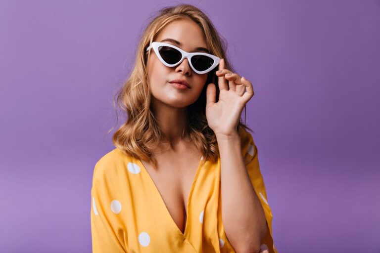 Fashionable blonde woman in yellow clothes posing in elegant sun