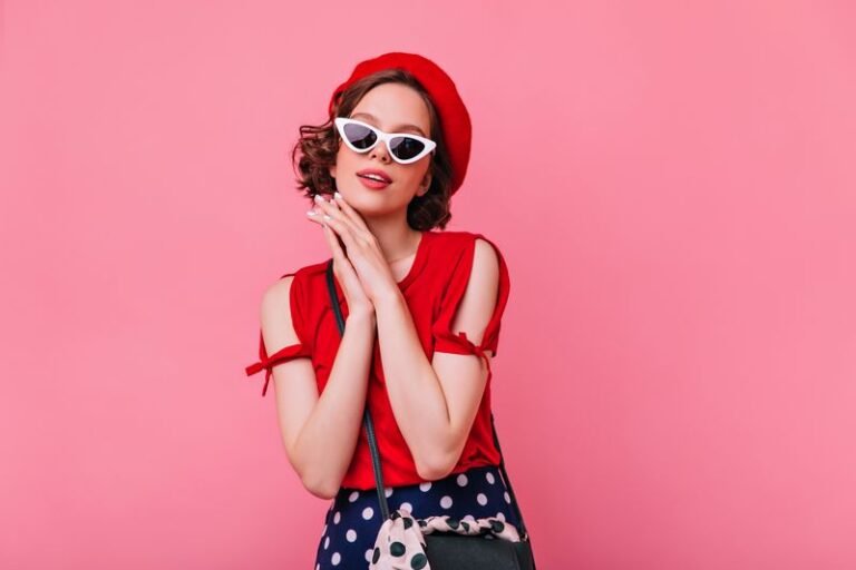 Graceful pale girl in french beret standing on pastel background